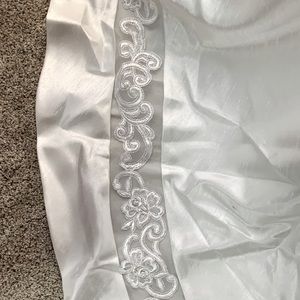 Wedding dress decorations around bottom and shoulders along with pearls